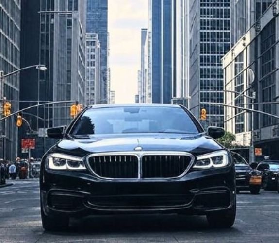 Black BMW driving in city street