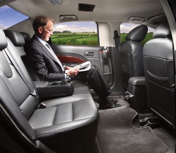 Businessman reading inside luxury car