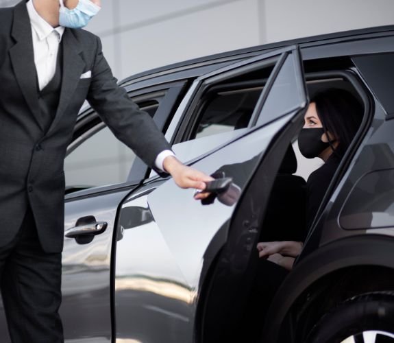 Chauffeur opening car door for passenger
