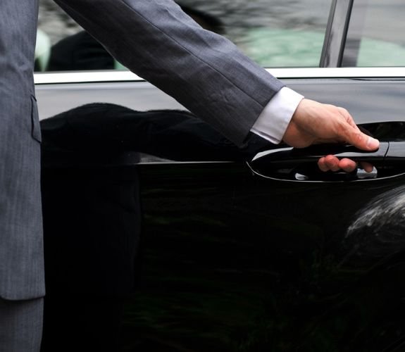 Chauffeur’s hand opening car door