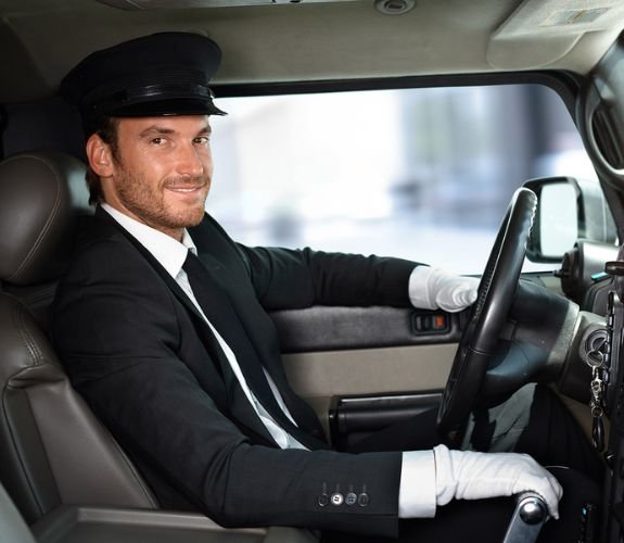 Smiling chauffeur sitting in driver’s seat