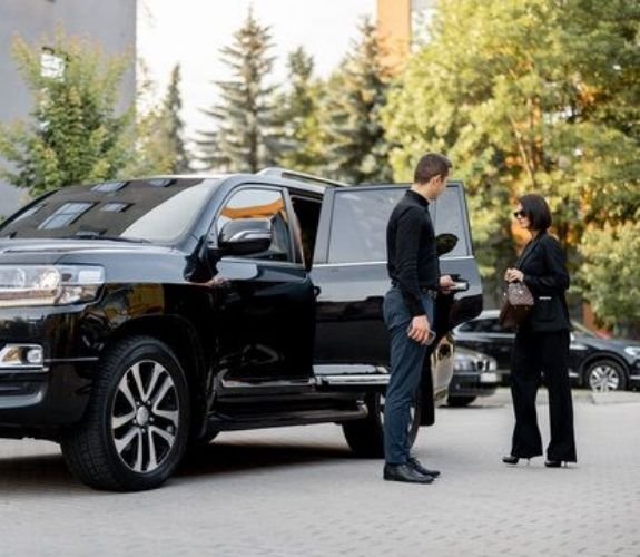 chuaffuer opening a door of an SUV for a lady chuaffuer opening a door of an SUV for a lady